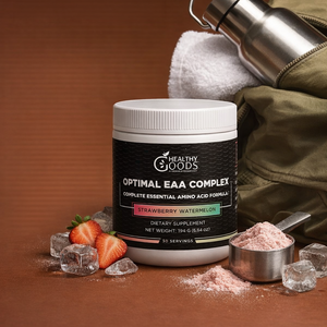 Container of 'Healthy Goods' EAA Complex with strawberries, ice cubes, and a measuring spoon on a brown background
