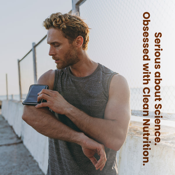 Man holding a smartphone with text 'Obsessed with Clean Nutrition' on a blurred background