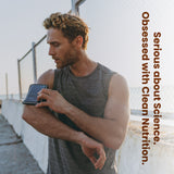 Man holding a smartphone with text 'Obsessed with Clean Nutrition' on a blurred background