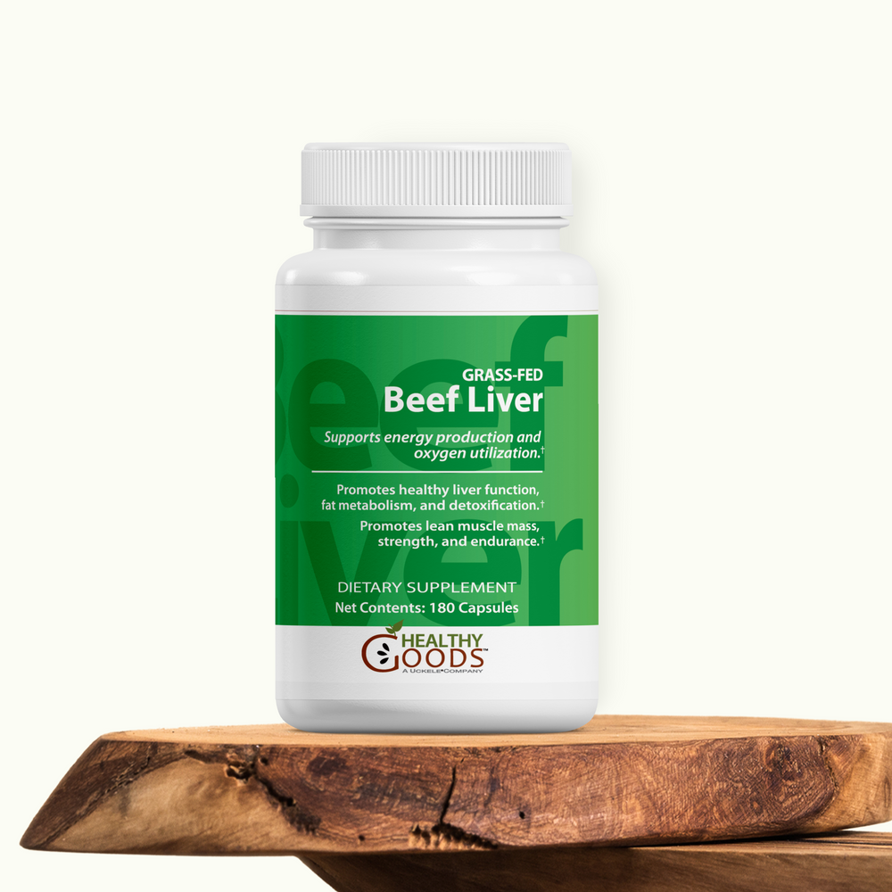 Supplement bottle labeled 'Grass-Fed Beef Liver' on a wooden surface with a white background