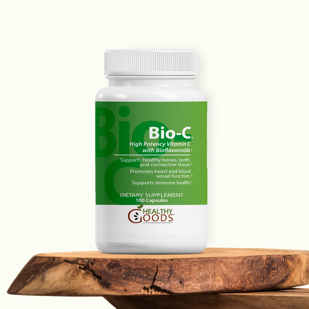 Supplement bottle labeled 'Bio-C' on a wooden surface with a white background