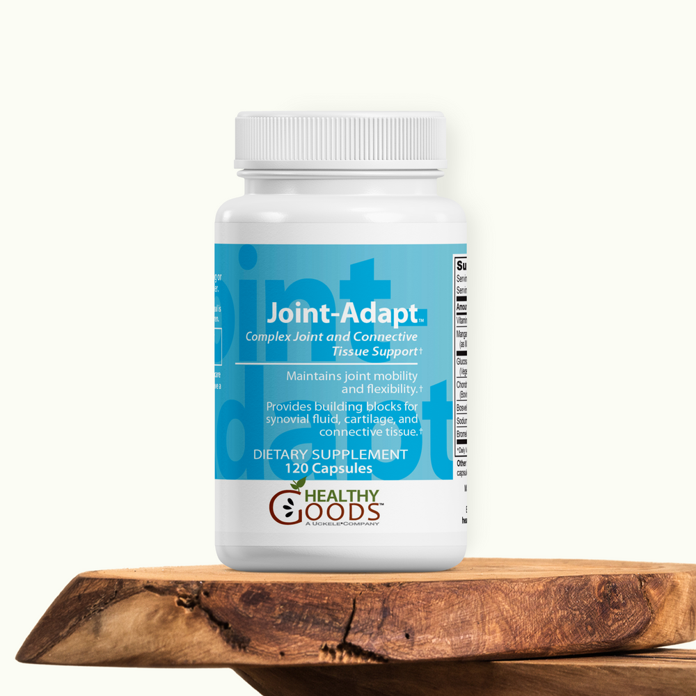 Supplement bottle labeled 'Joint-Adapt' on a wooden surface with a white background
