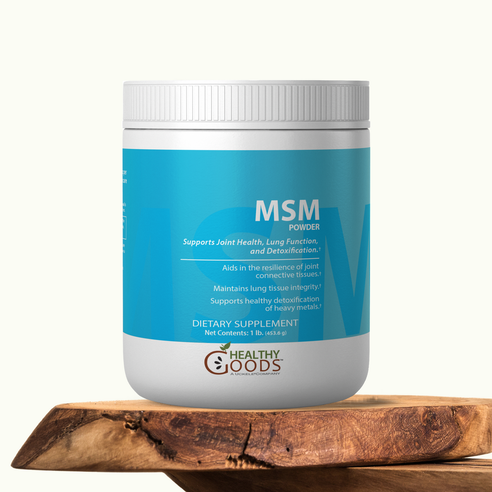 Container of MSM powder by Healthy Goods on a wooden surface with a white background