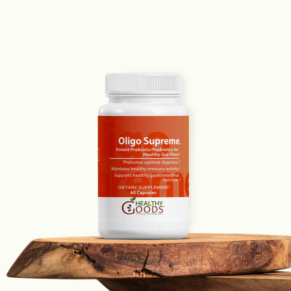Supplement bottle labeled 'Oligo Supreme' by 'Healthy Goods' on a wooden surface with a white background