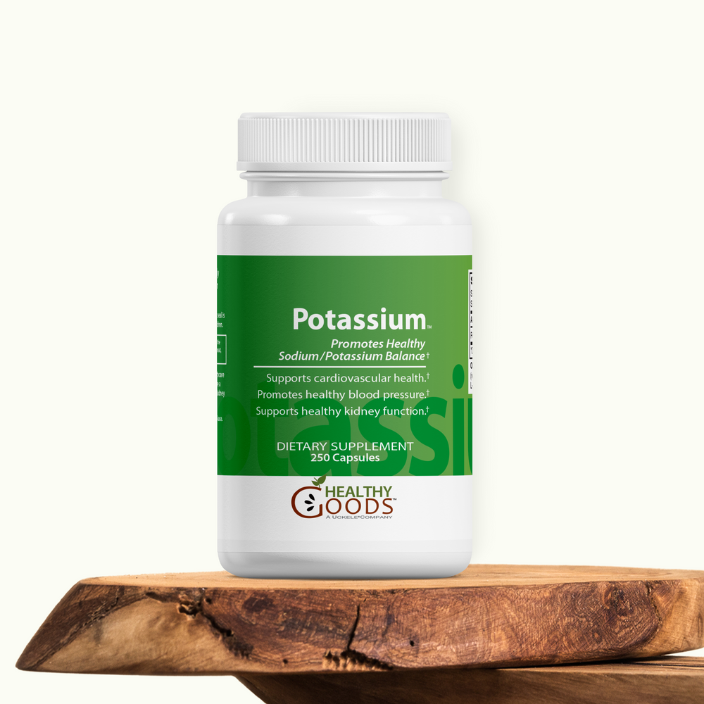 Supplement bottle labeled 'Potassium' by 'Healthy Goods' on a wooden surface with a white background
