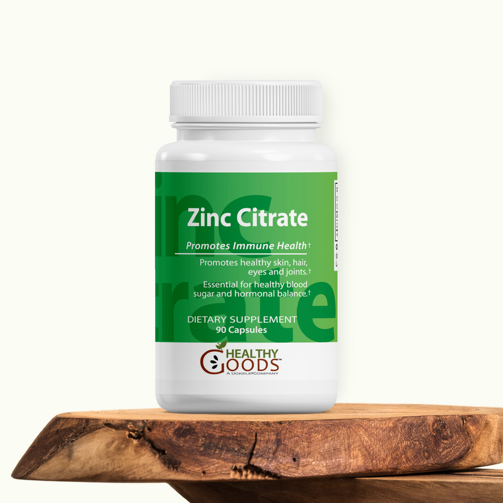 Supplement bottle labeled 'Zinc Citrate' by Healthy Goods on a wooden surface with a white background
